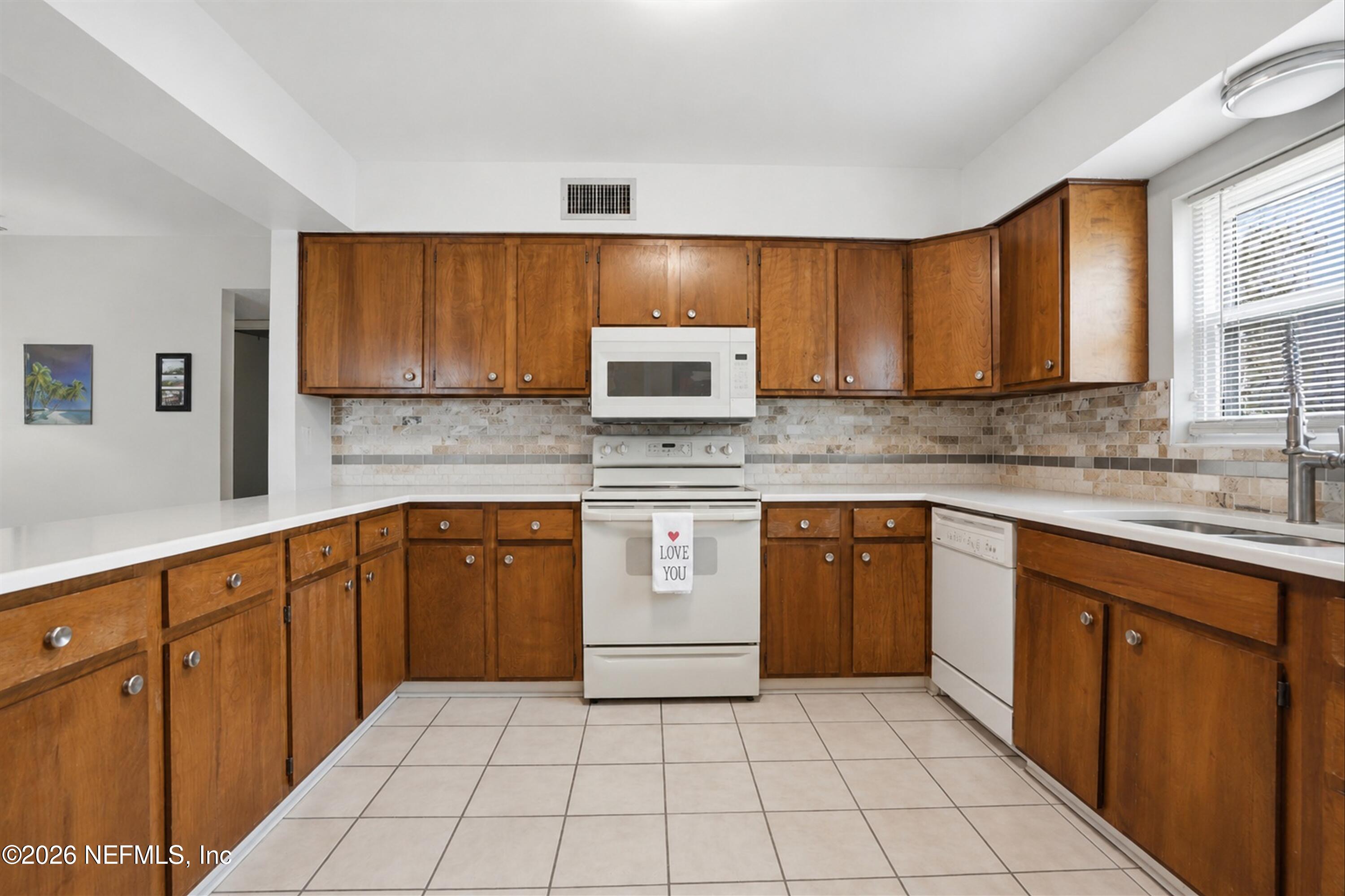 124 Hopkins Street Neptune Beach, FL 32266 - Photo 21 of 44 a kitchen with stainless steel appliances granite countertop a sink stove and cabinets