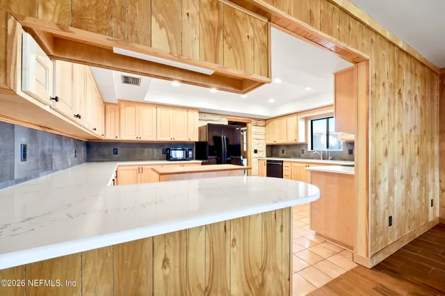 a view of kitchen with stainless steel appliances granite countertop a refrigerator and a stove