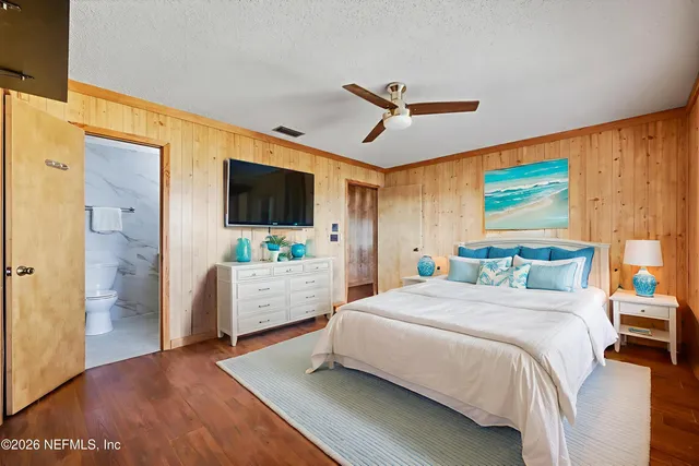 a bedroom with a bed a flat screen tv and a couch