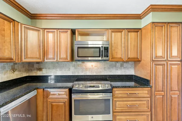 a kitchen with stainless steel appliances granite countertop a stove and a microwave