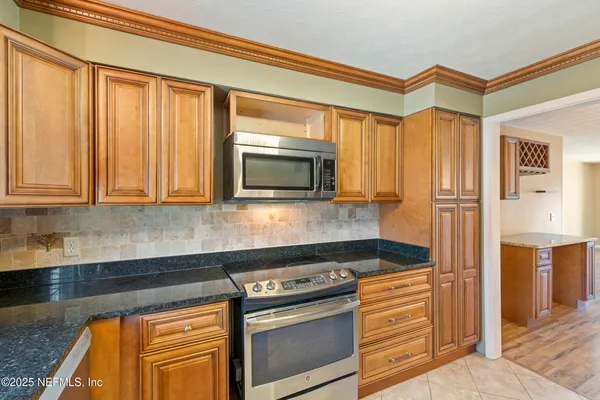 a kitchen with stainless steel appliances granite countertop a stove and a microwave