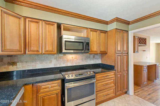 a kitchen with stainless steel appliances granite countertop a stove and a microwave