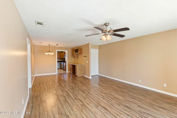 a view of an empty room with wooden floor