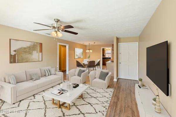 a living room with furniture flat screen tv and a chandelier