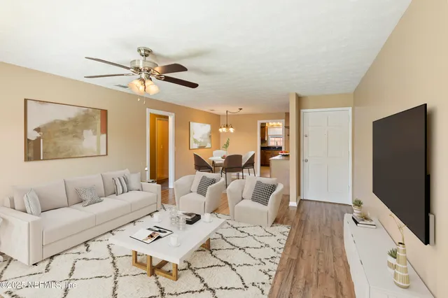 a living room with furniture flat screen tv and a chandelier