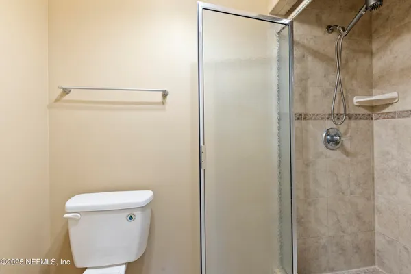 a bathroom with a toilet and a shower