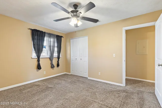 an empty room with chandelier fan