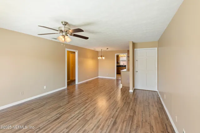 a view of an empty room with wooden floor