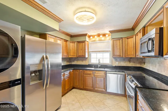 a kitchen with a sink cabinets and stainless steel appliances