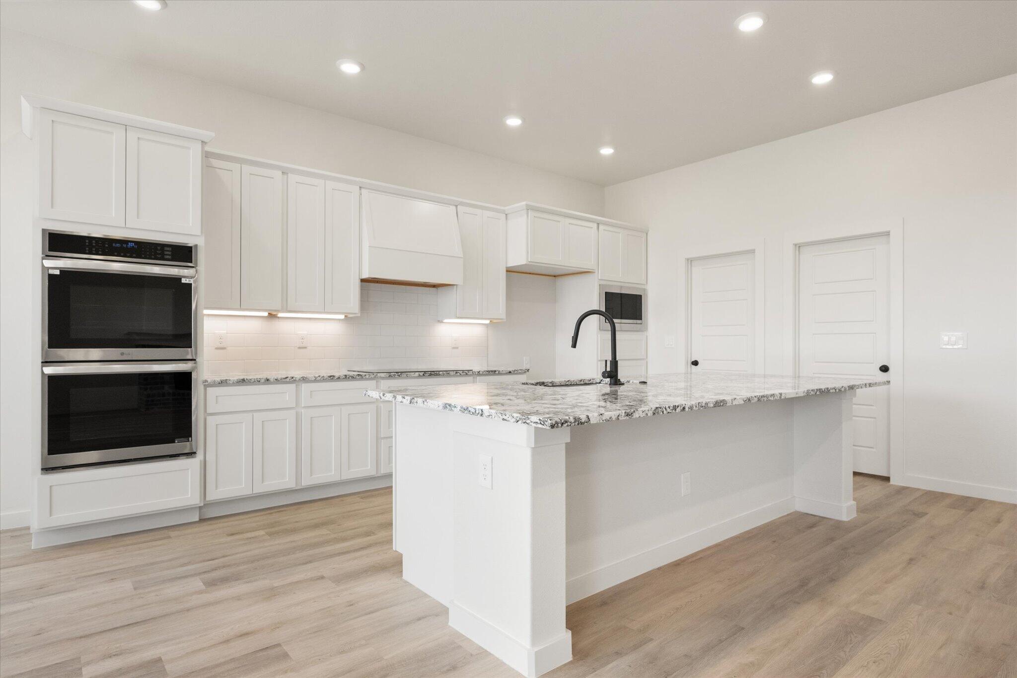 6103 121st Street Lubbock, TX 79424 - Photo 12 of 30 a kitchen with stainless steel appliances granite countertop a stove a sink and a microwave