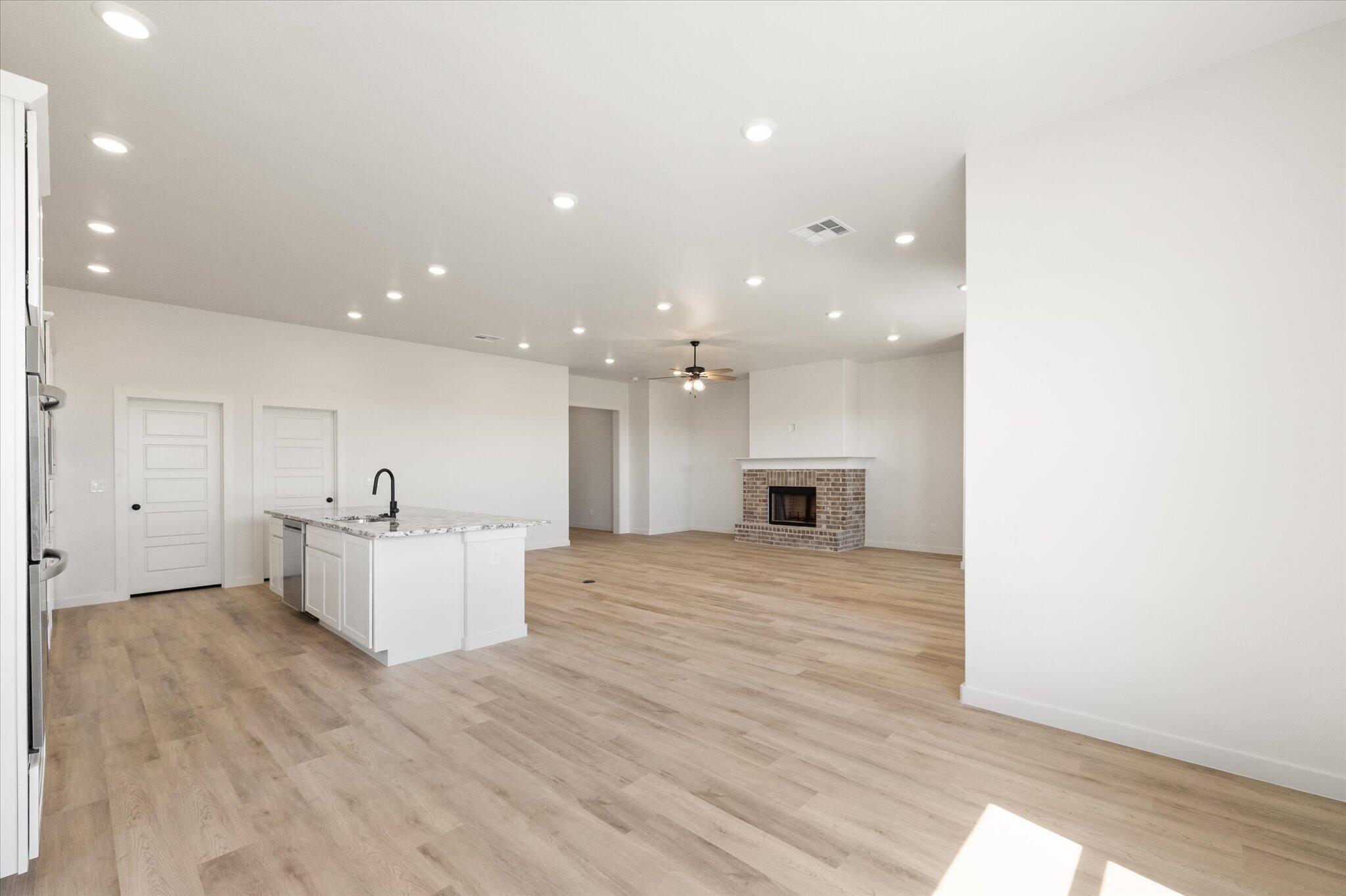 6103 121st Street Lubbock, TX 79424 - Photo 16 of 30 a view of kitchen with kitchen island sink refrigerator and white cabinets