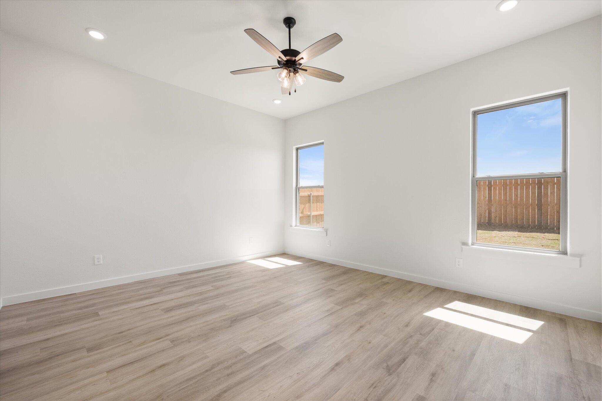 6103 121st Street Lubbock, TX 79424 - Photo 18 of 30 an empty room with wooden floor and windows