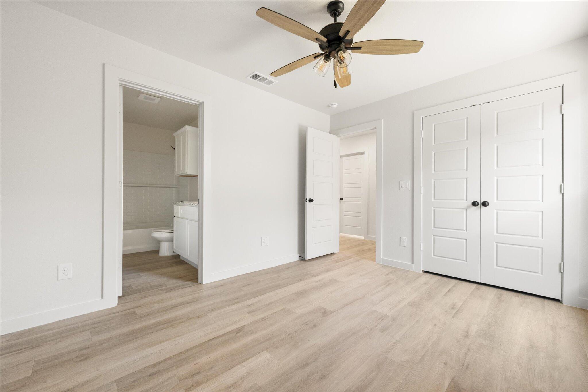 6103 121st Street Lubbock, TX 79424 - Photo 23 of 30 wooden floor in an empty room with a bathroom