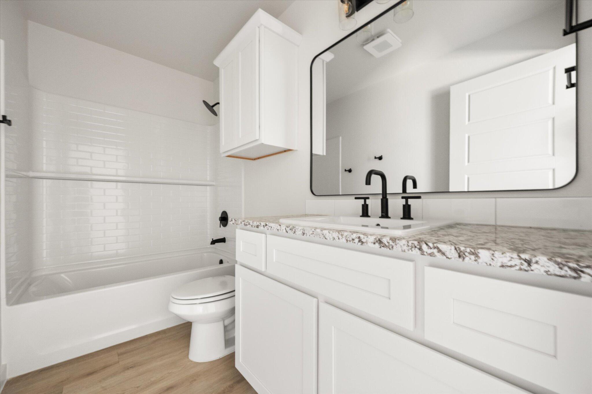 6103 121st Street Lubbock, TX 79424 - Photo 24 of 30 a bathroom with a sink a toilet and a large mirror