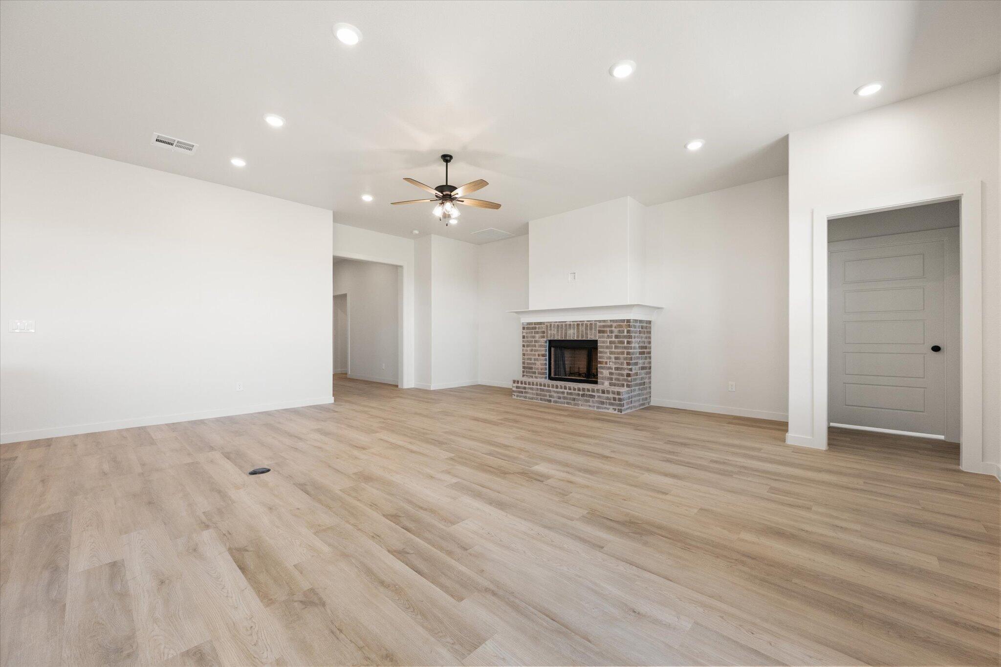 6103 121st Street Lubbock, TX 79424 - Photo 5 of 30 an empty room with wooden floor and kitchen view