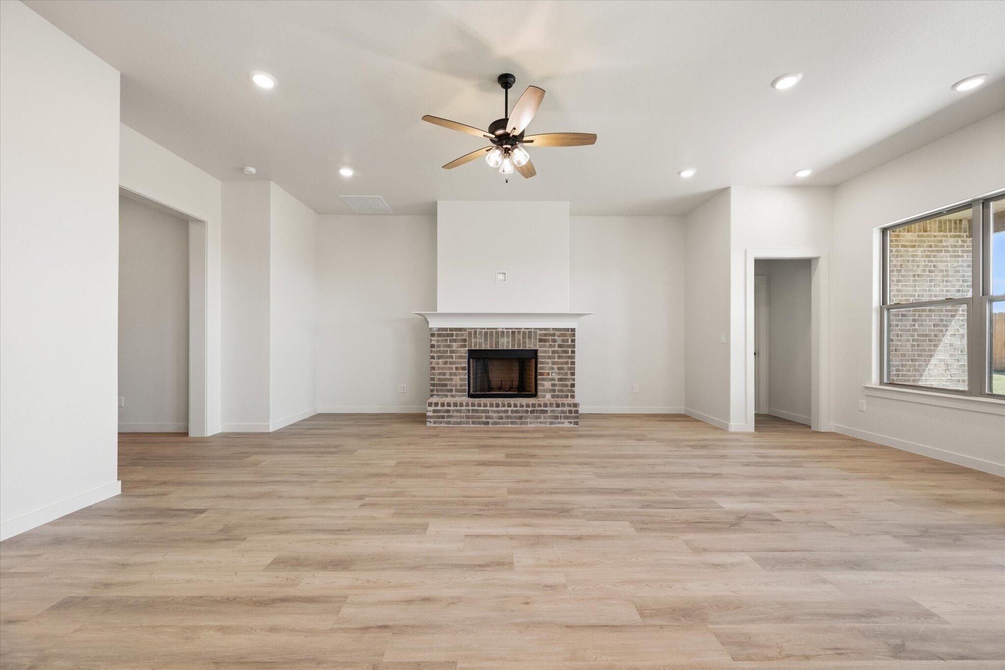 6103 121st Street Lubbock, TX 79424 - Photo 7 of 30 a view of an empty room with a fireplace and a window