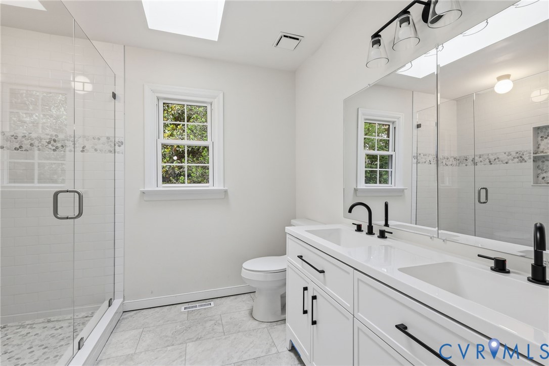 12111 Auger Lane Midlothian, VA 23113 - Photo 16 of 31 a bathroom with a double vanity sink toilet and shower