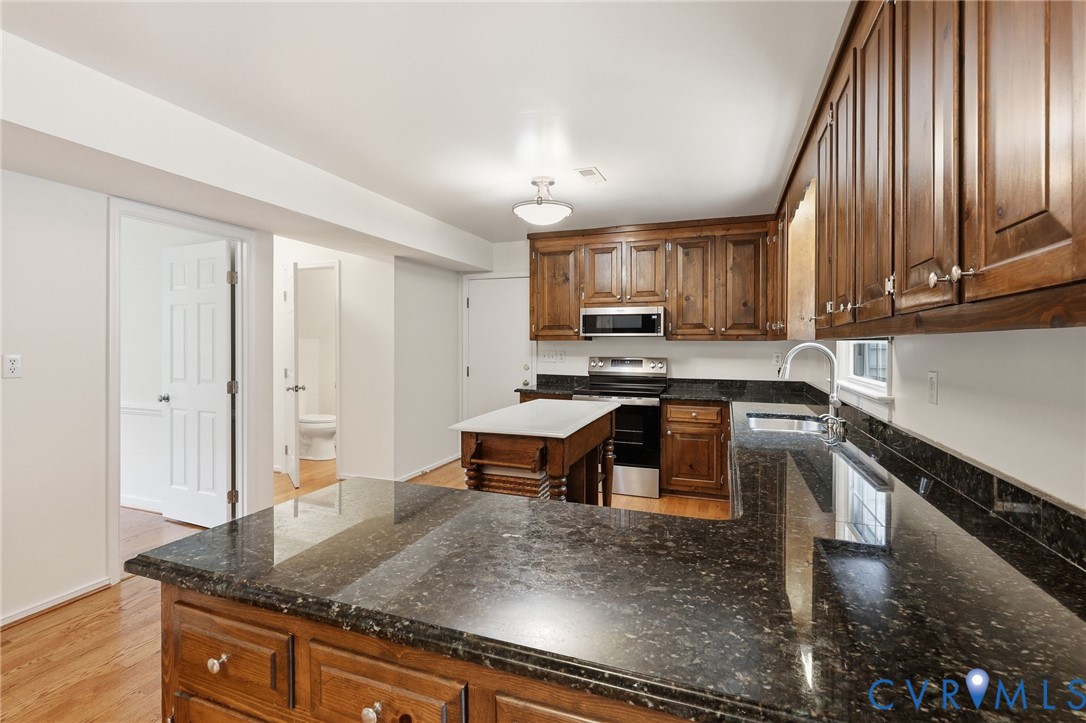 12111 Auger Lane Midlothian, VA 23113 - Photo 9 of 31 a kitchen with kitchen island granite countertop a stove a sink and a granite counter tops