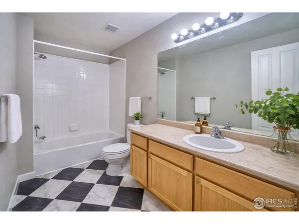 a bathroom with a granite countertop sink a mirror a bathtub and a shower