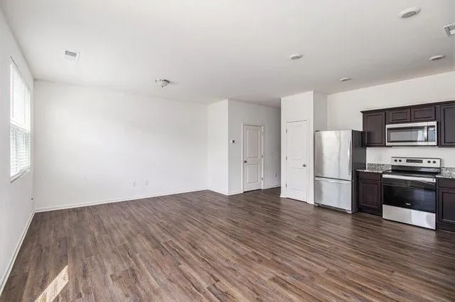 a view of kitchen with stainless steel appliances wooden floor and electronic appliances