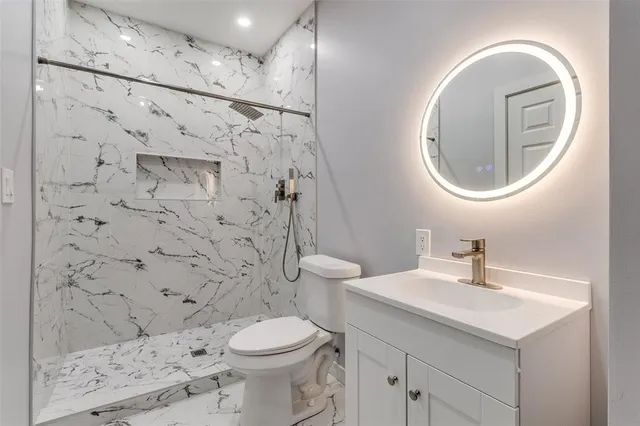 a bathroom with a sink a toilet and shower