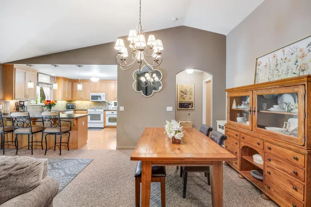 a dining room with stainless steel appliances a dining table and chairs