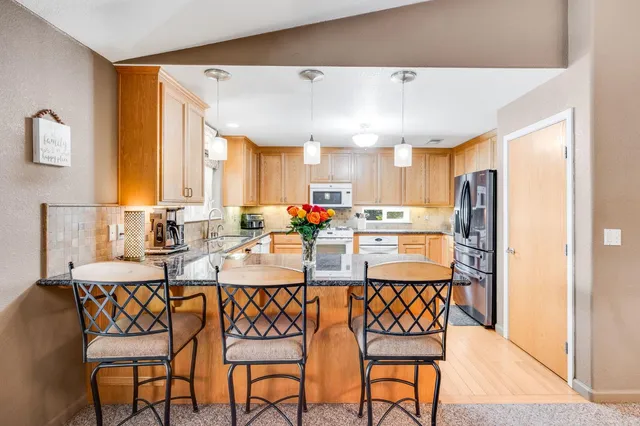 a kitchen with cabinets stainless steel appliances and wooden floor