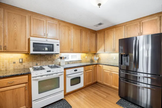 a large kitchen with a table and chairs