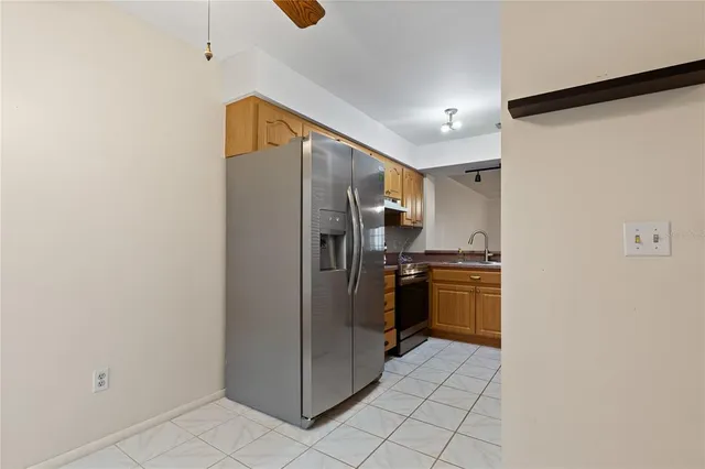 a kitchen with a refrigerator and stove top oven