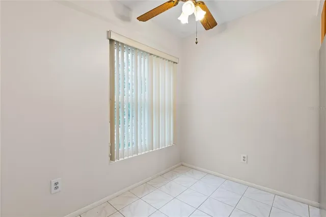 an empty room with chandelier fan