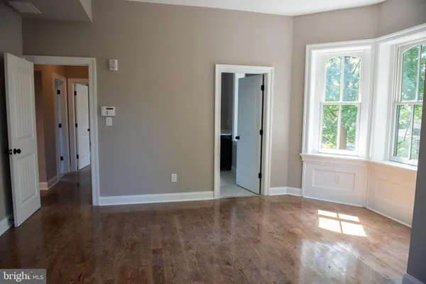 an empty room with windows and closet