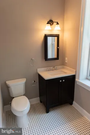 a bathroom with a toilet sink vanity and mirror