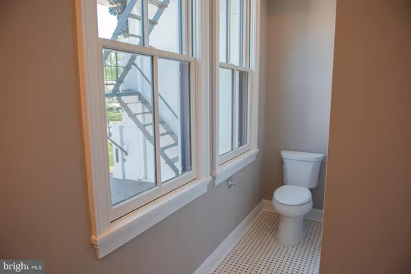 a bathroom with a toilet and a window