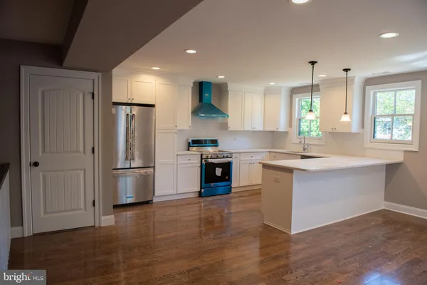 a kitchen with stainless steel appliances granite countertop a refrigerator and a stove top oven