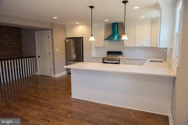 a kitchen with stainless steel appliances granite countertop a sink a stove and a refrigerator