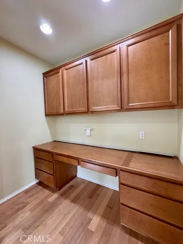 a view of kitchen with wooden floor and cabinets