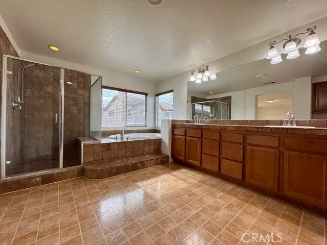 a large bathroom with a large tub shower and sink