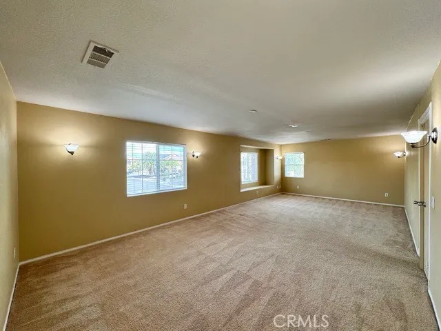 a view of an empty room with window and a fireplace