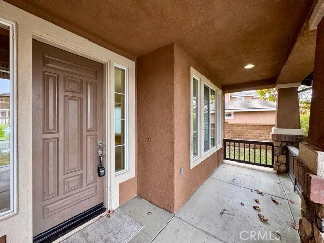 a view of a porch with a door and wooden floor