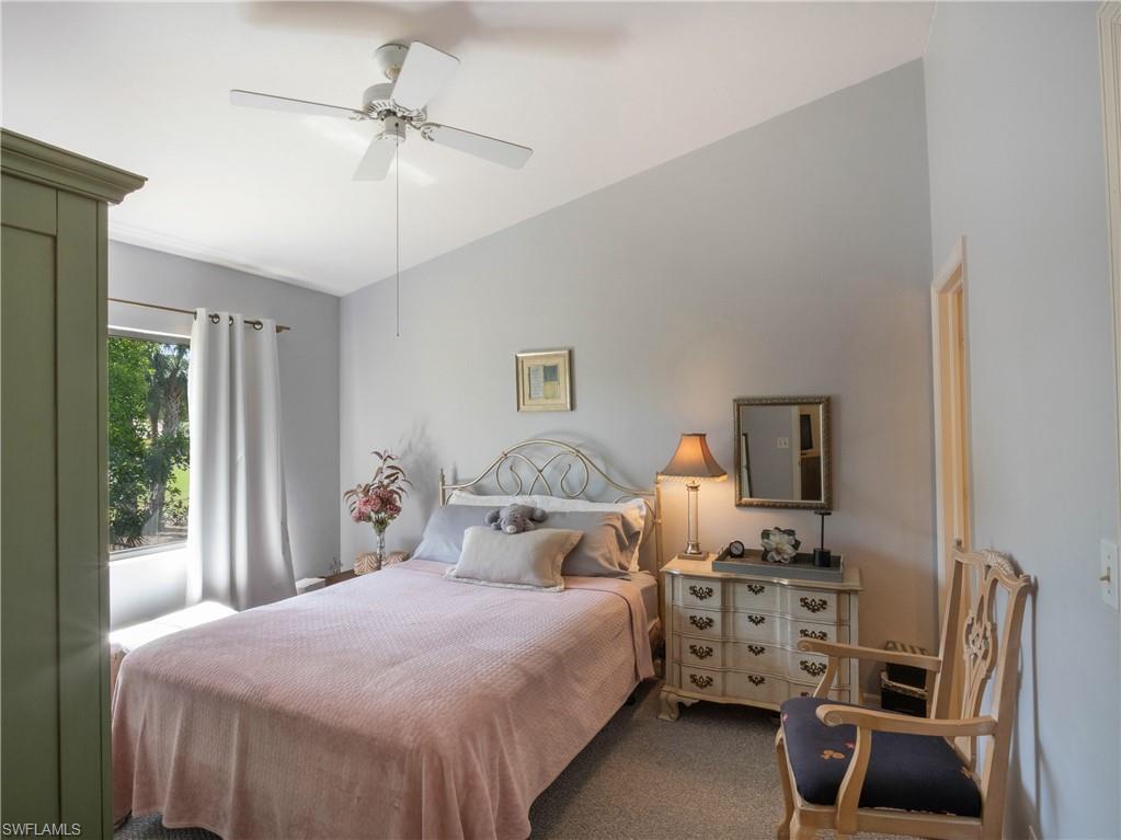 5857 Rattlesnake Hamm Road, Unit 204 Naples, FL 34113 - Photo 11 of 15 a bedroom with a bed and a chandelier
