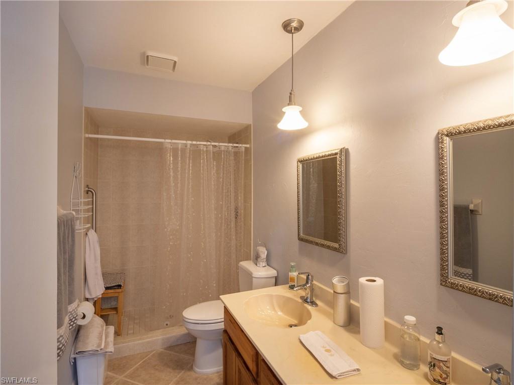 5857 Rattlesnake Hamm Road, Unit 204 Naples, FL 34113 - Photo 12 of 15 a bathroom with a sink a toilet a mirror and shower