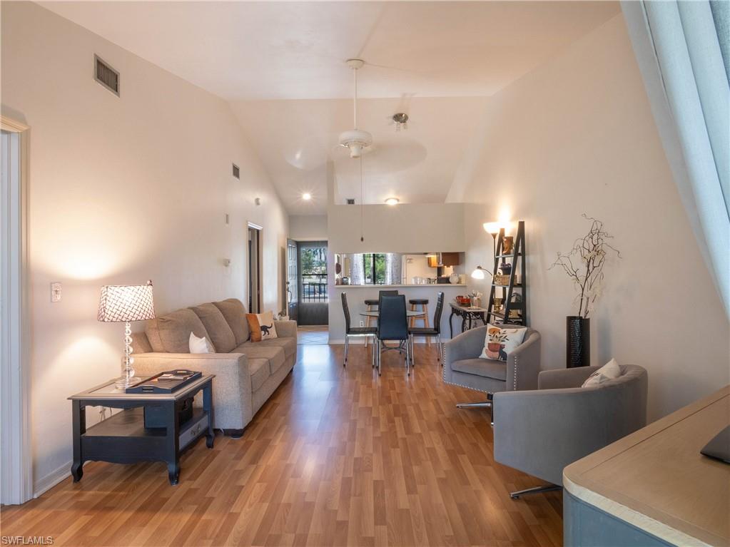 5857 Rattlesnake Hamm Road, Unit 204 Naples, FL 34113 - Photo 13 of 15 a living room with furniture and wooden floor