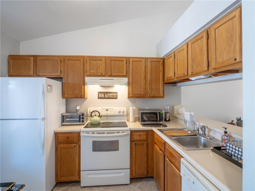 5857 Rattlesnake Hamm Road, Unit 204 Naples, FL 34113 - Photo 2 of 15 a kitchen with a sink cabinets and refrigerator