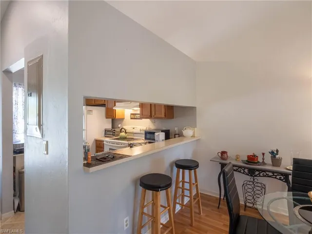 a kitchen with stainless steel appliances a table and chairs in it