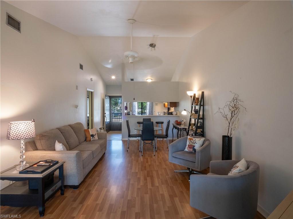 5857 Rattlesnake Hamm Road, Unit 204 Naples, FL 34113 - Photo 6 of 15 a living room with furniture and wooden floor