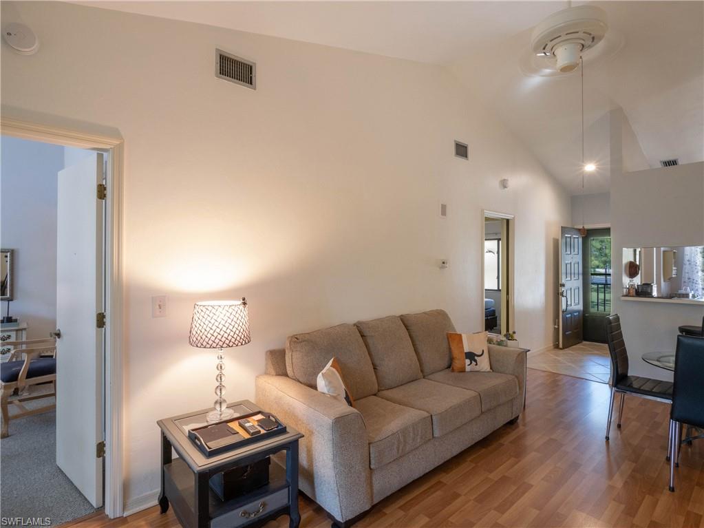 5857 Rattlesnake Hamm Road, Unit 204 Naples, FL 34113 - Photo 7 of 15 a living room with furniture a lamp and a table