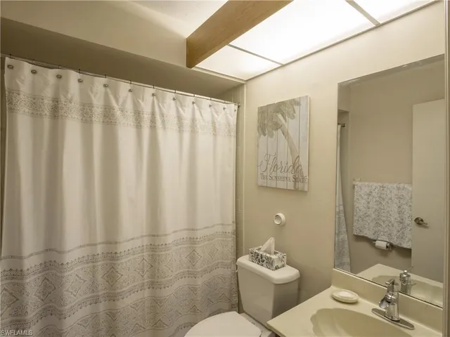 a bathroom with a sink mirror and a toilet