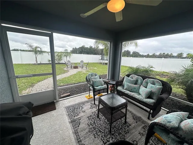 a living room with furniture and a floor to ceiling window