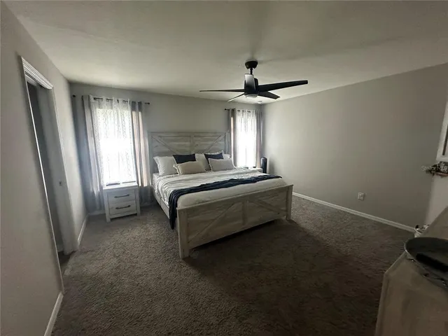 a bedroom with a bed and a ceiling fan