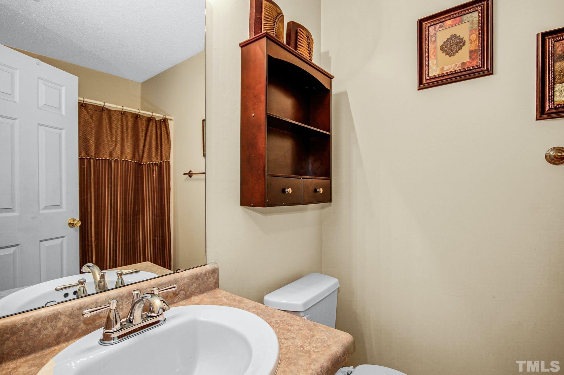5925 Wessel Way Raleigh, NC 27610 - Photo 13 of 29 a bathroom with a sink and a mirror